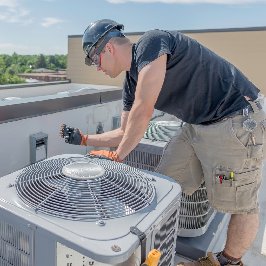 HVAC technician servicing equipment on a commercial rooftop